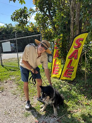 guy dog in front of sale sign